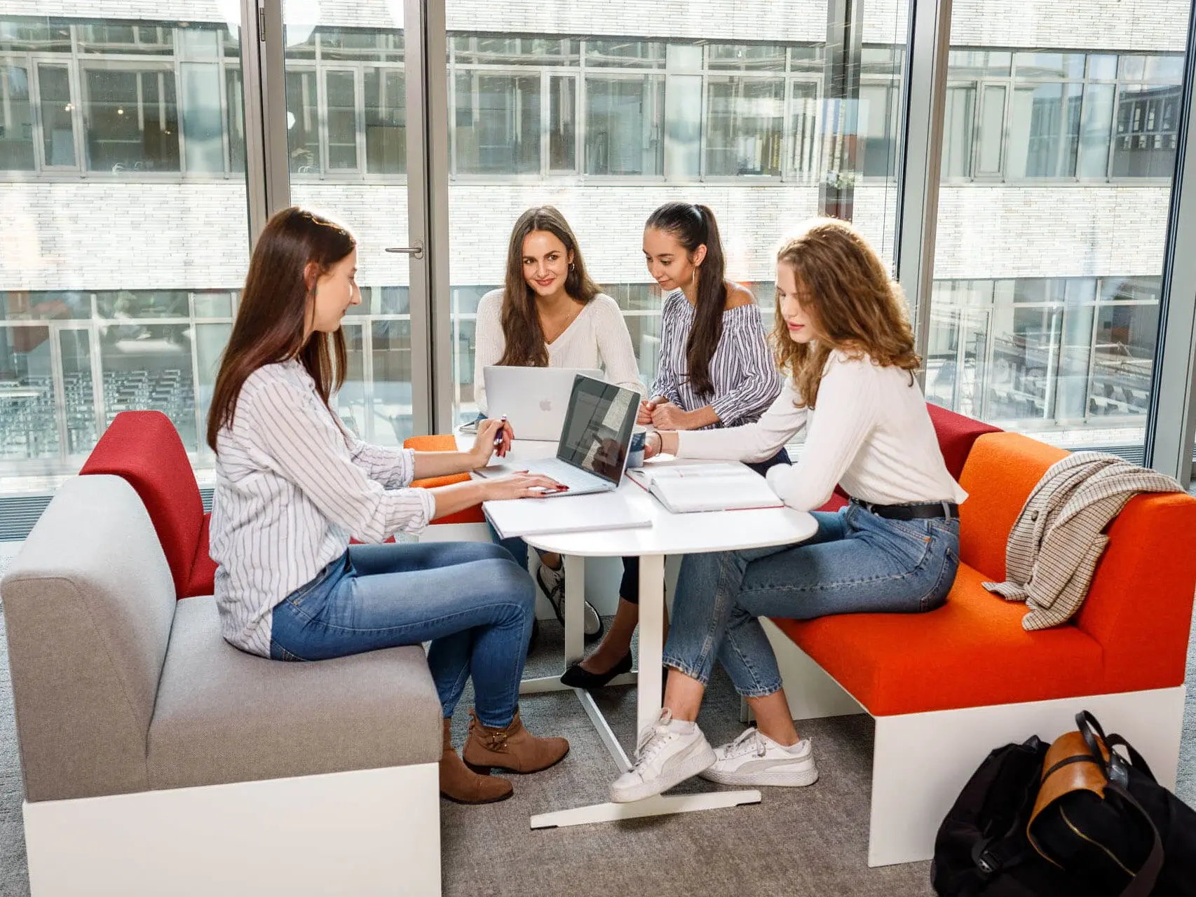 Vier Mädchen unterhalten sich in der Universitätsbibliothek