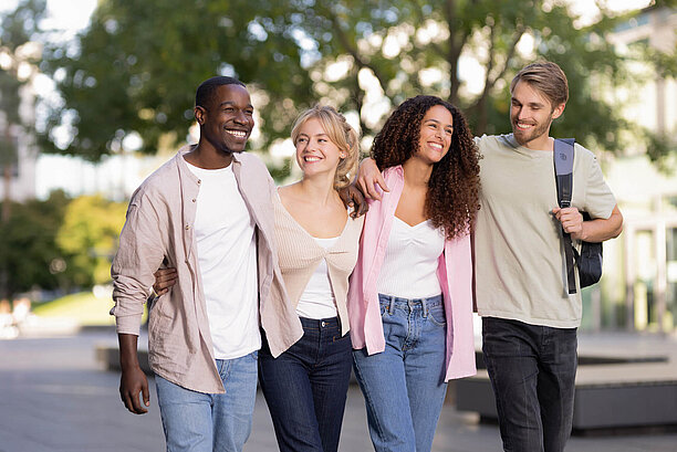 Four students in front of campus
