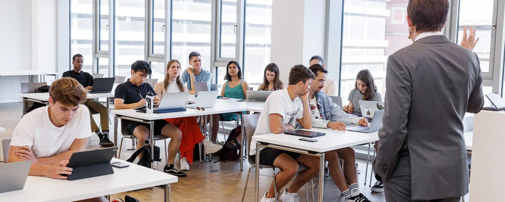 Professor hält eine Vorlesung vor einem vollen Klassenraum mit Studenten