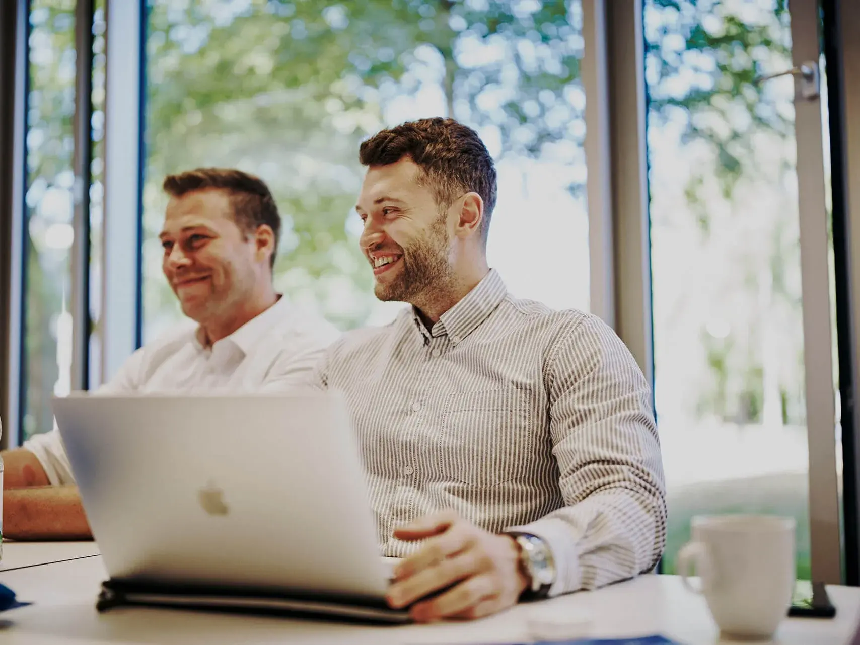 [Translate to German:] 2 men in front of a laptop