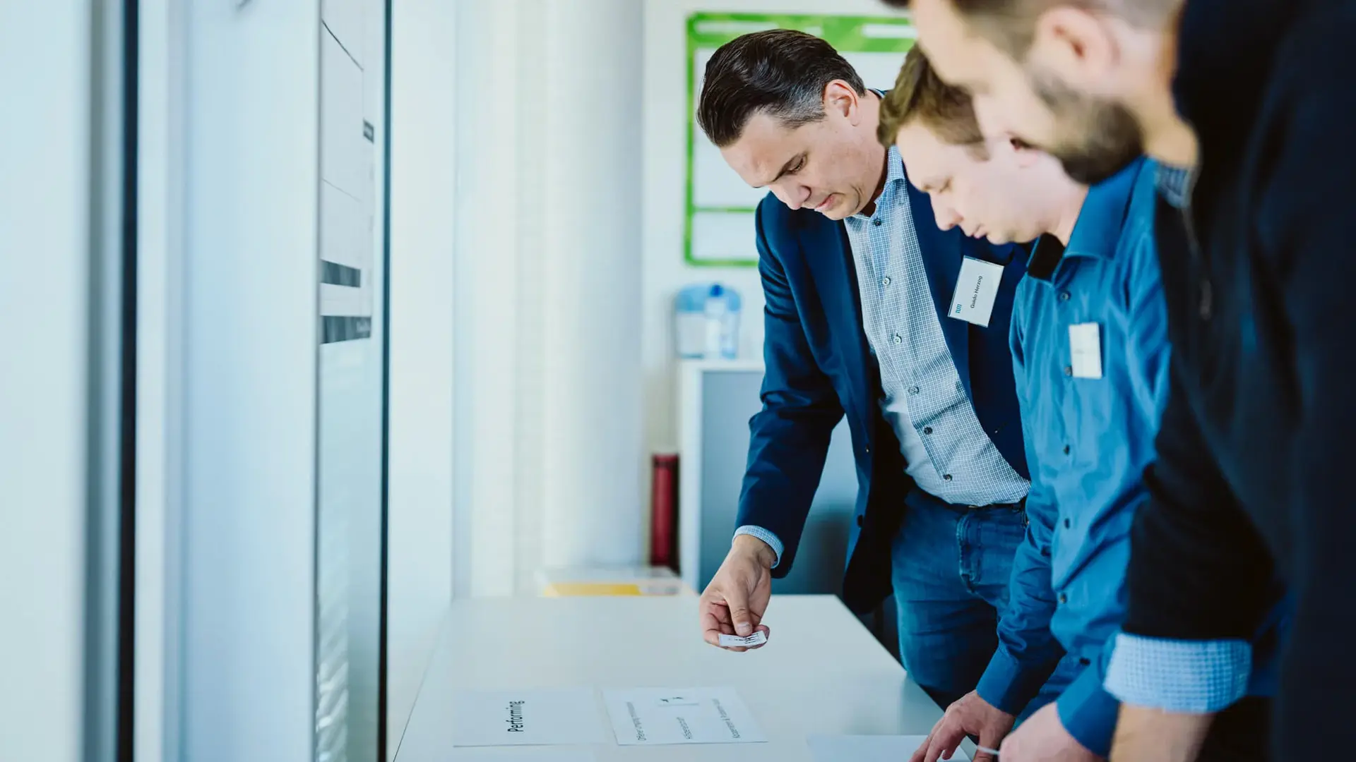 Drei Männer stehen vor einem Schreibtisch und machen ein Brainstorming während einer Arbeit