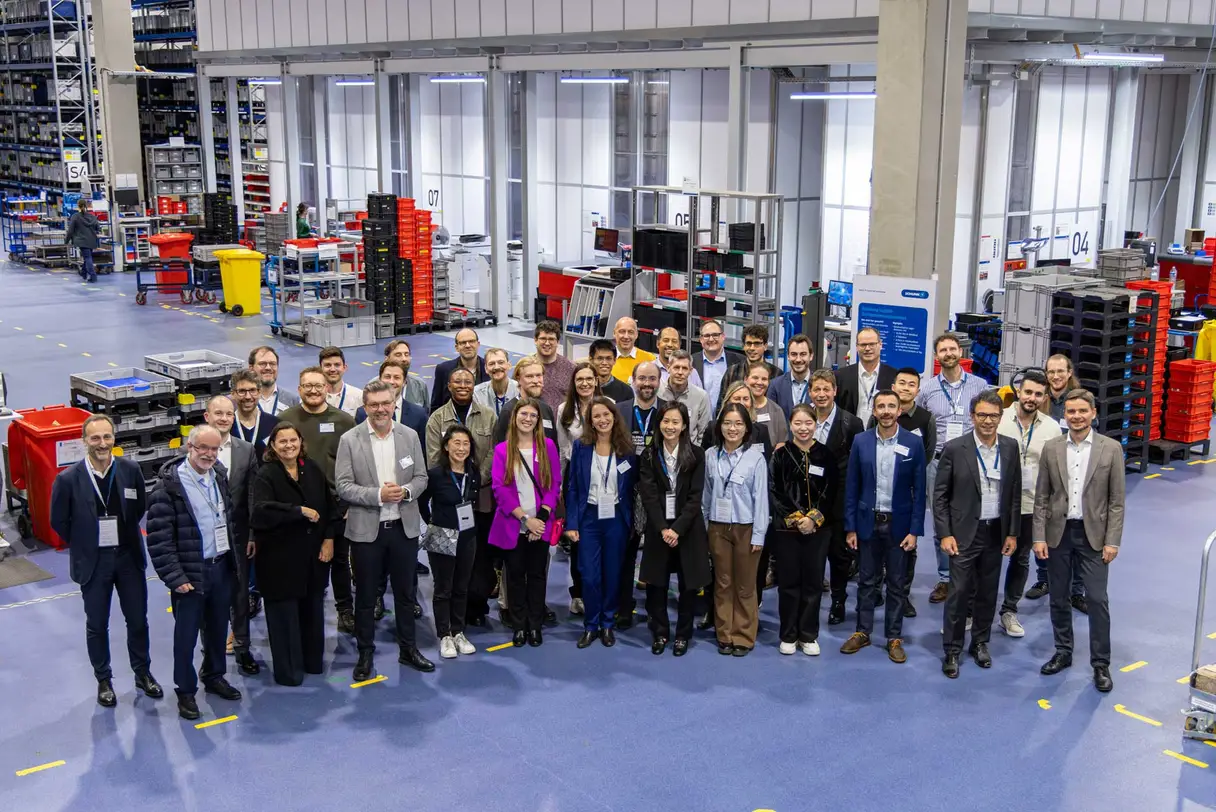 a group of women and men standing in a factory hall