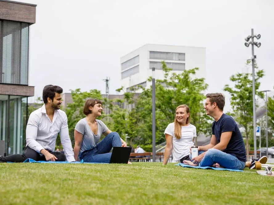 Studenten sitzen auf dem Rasen des Campus