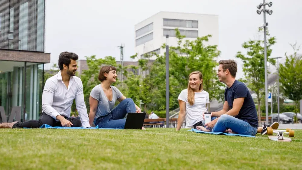 Students sitting on the grass at campus