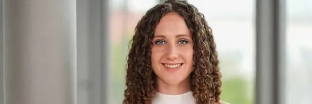 [Translate to German:] portrait of a curly young woman