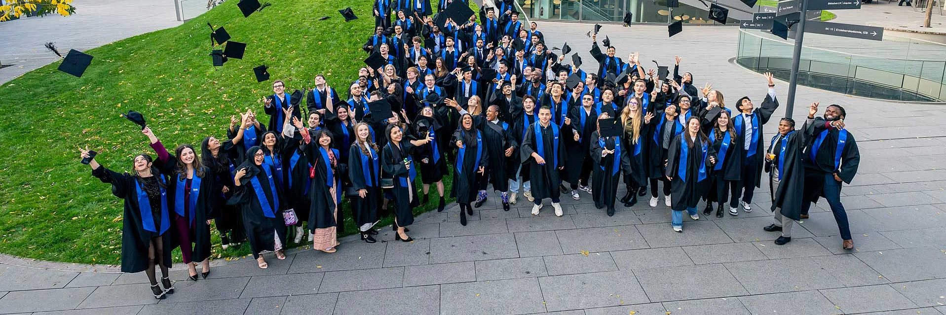 a group of students after graduation throwing their hats into the air