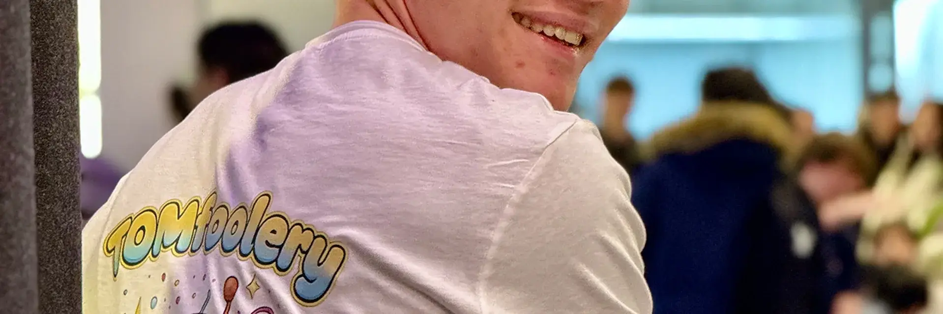 a young mans back, t-shirt with TOMfoolery print