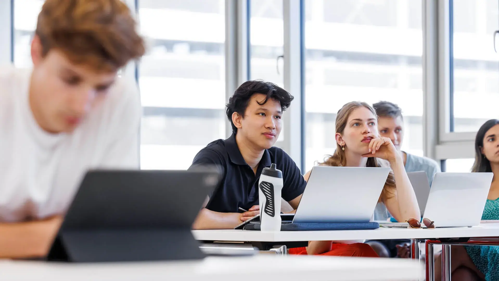 Young man in the classroom looking at his laptop