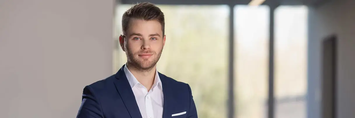 a young man in a suit leaning against a rail