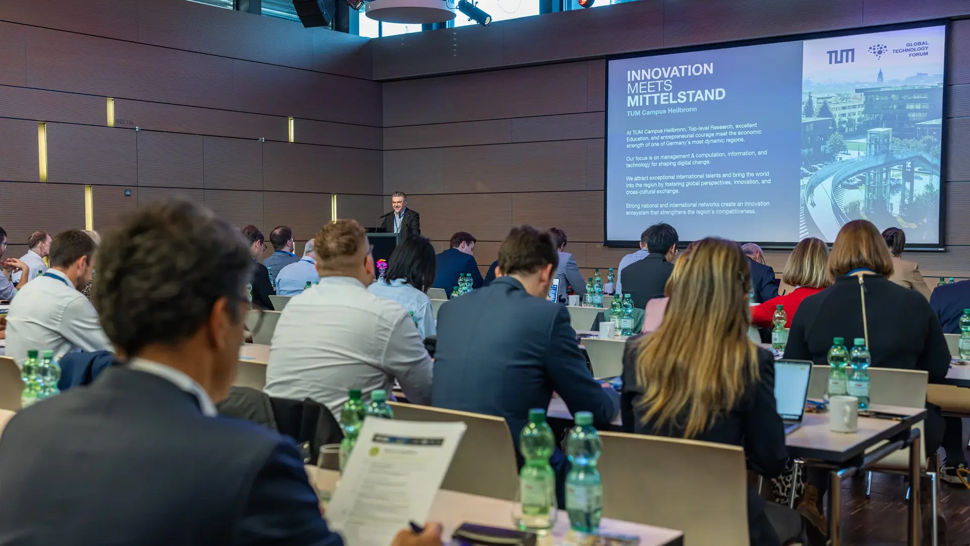 A conference room filled with professionals listens to a presentation on “Innovation meets Mittelstand” at the TUM Campus Heilbronn.