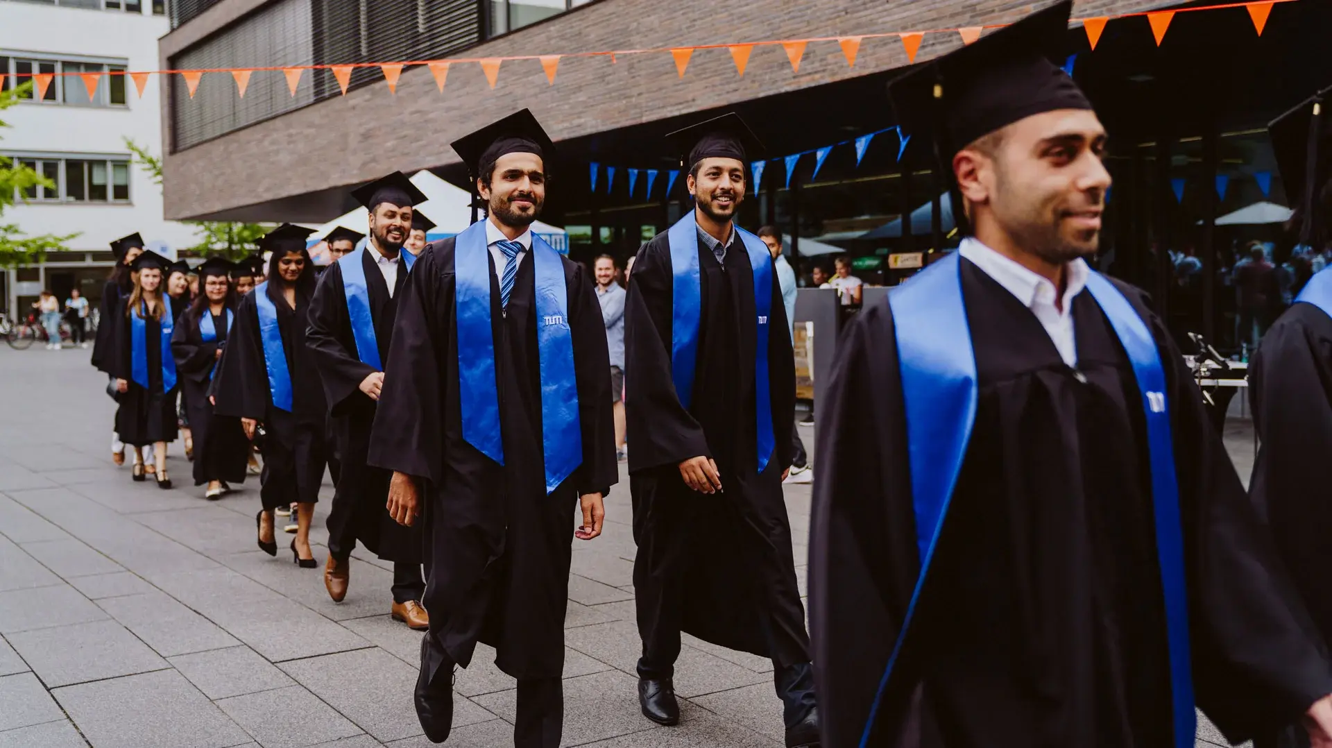 TUM-Absolventen beim Verlassen eines Campus-Gebäudes