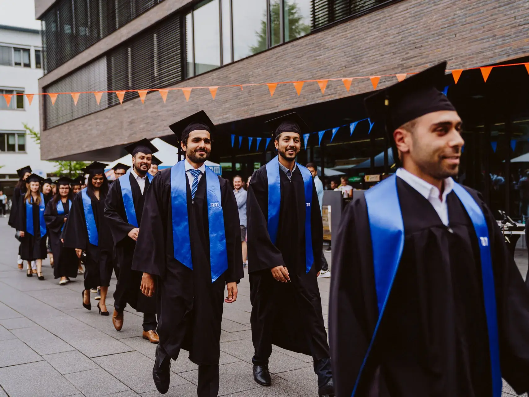 TUM graduates leaving a campus building