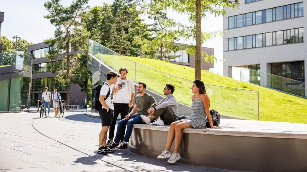 Studenten im Gespräch vor der Mensa auf dem Campus