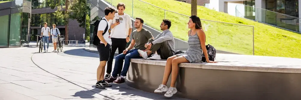 Studenten im Gespräch vor der Mensa auf dem Campus