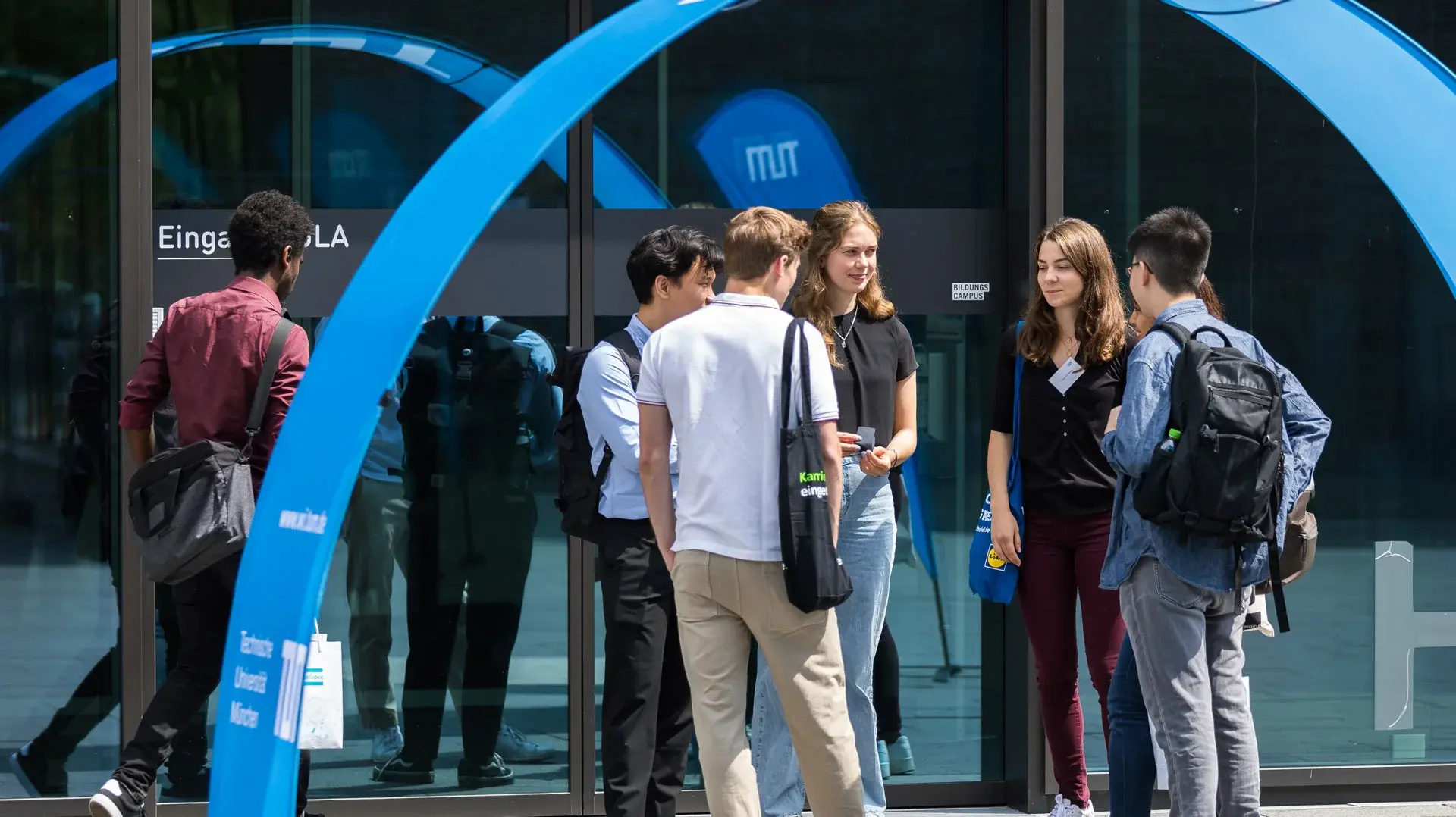 Menschen im Gespräch vor dem Eingang der TUM event career factory