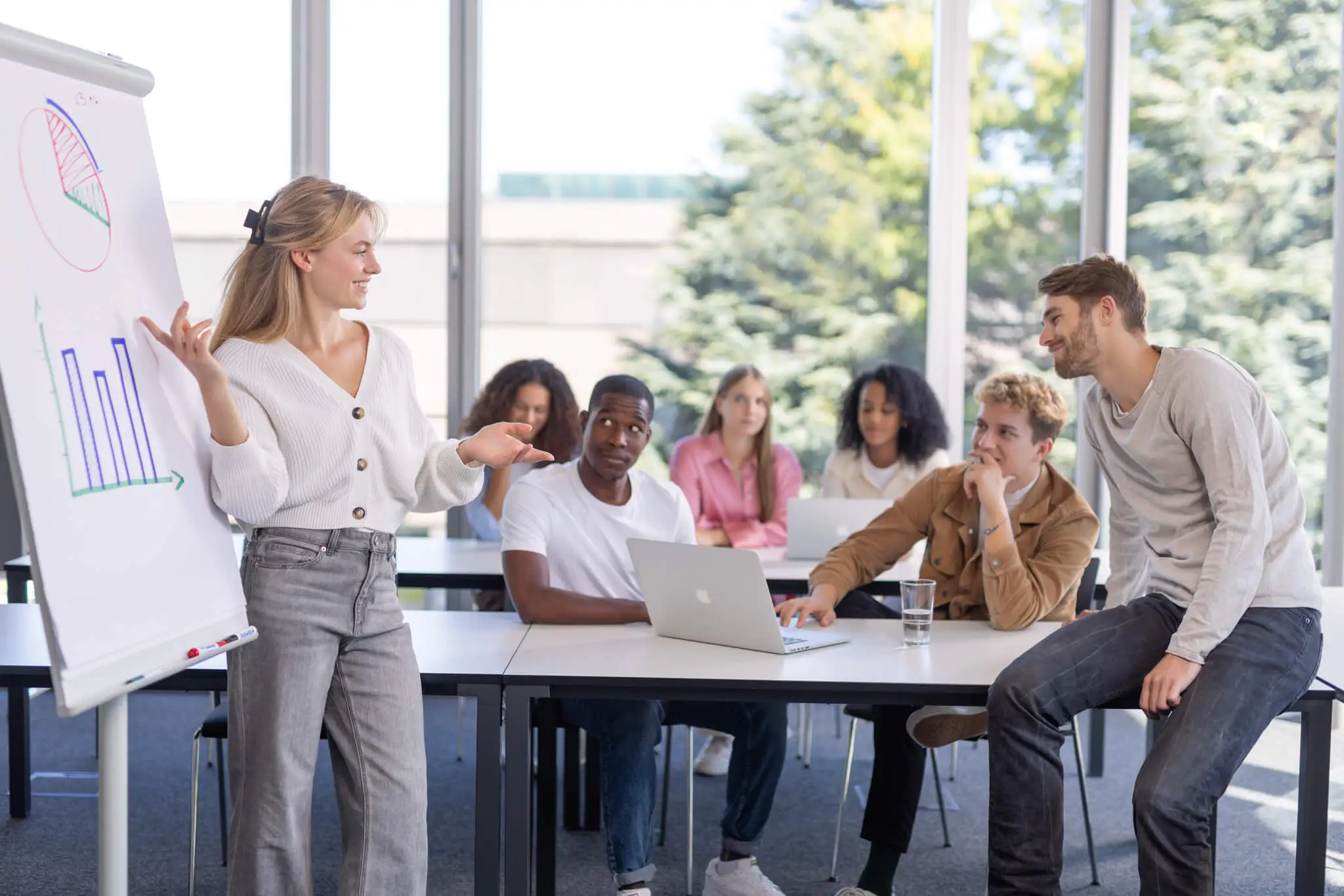 Young woman at a flip chart in front of students