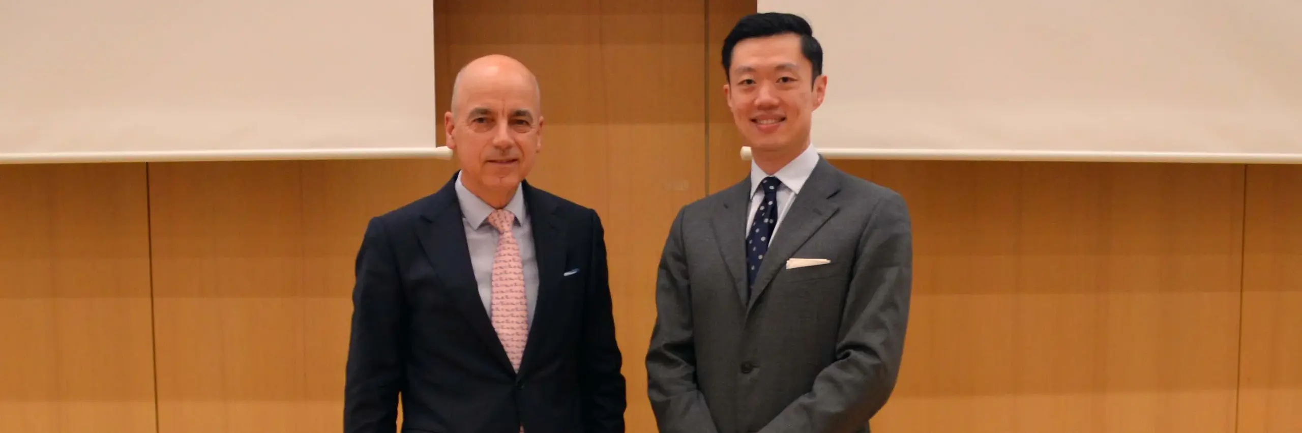 two men in suits standing next to each other