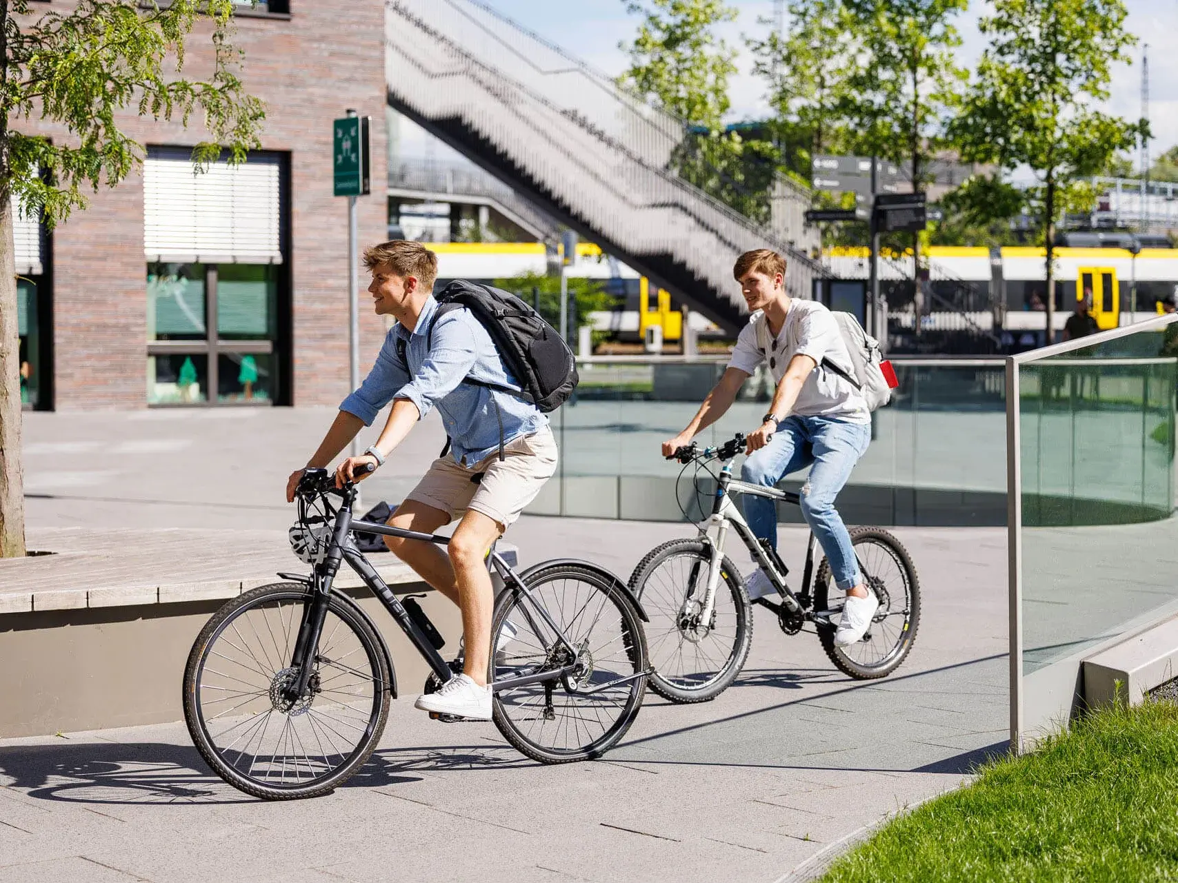 Two people riding bikes at campus