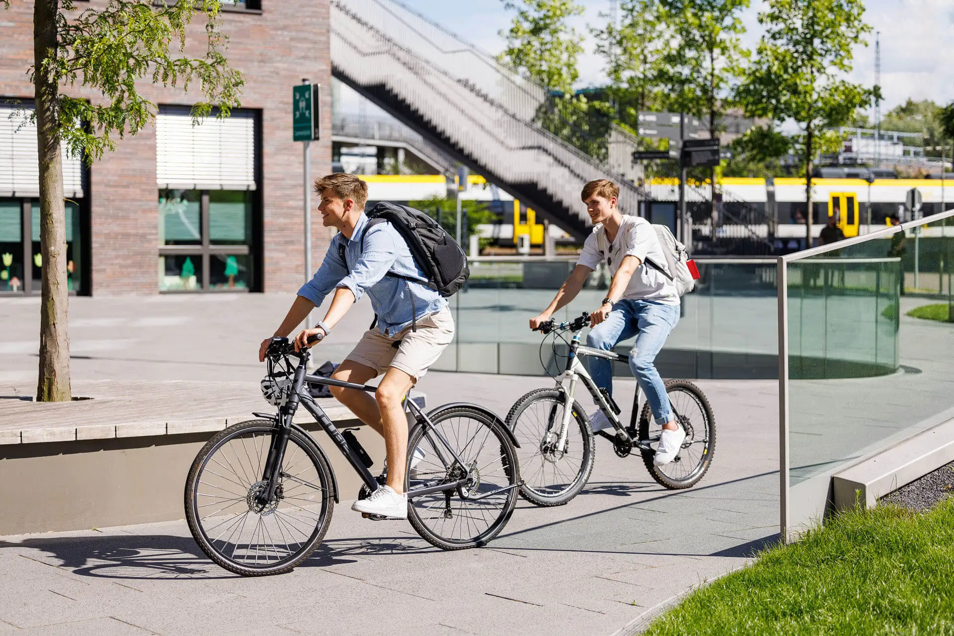 Two people riding bikes at campus