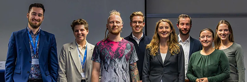 [Translate to German:] A group of women and men facing the camera