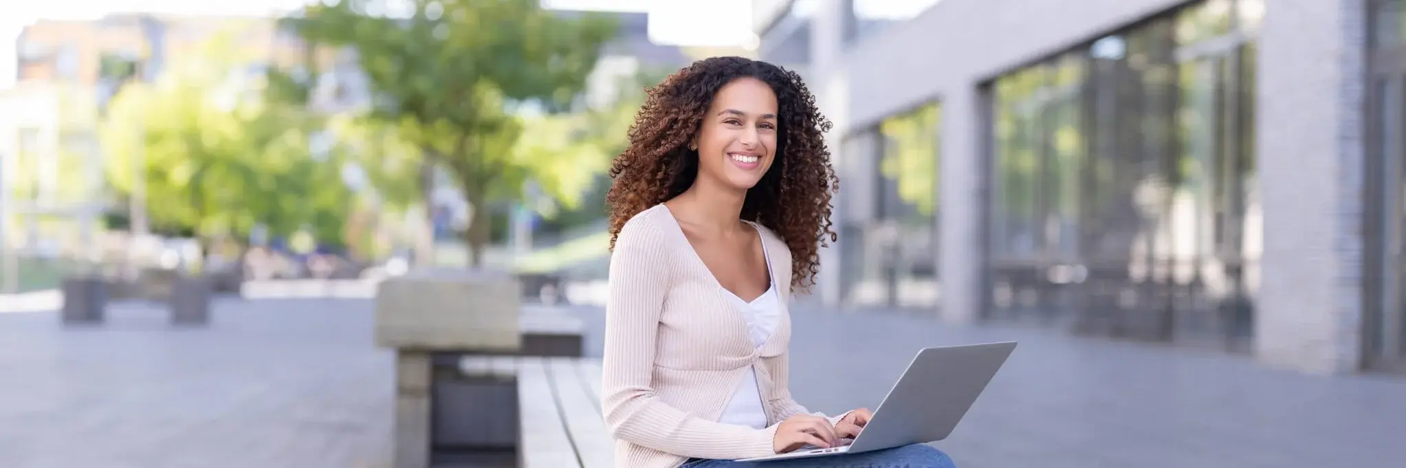 Student working on a laptop outside on campus