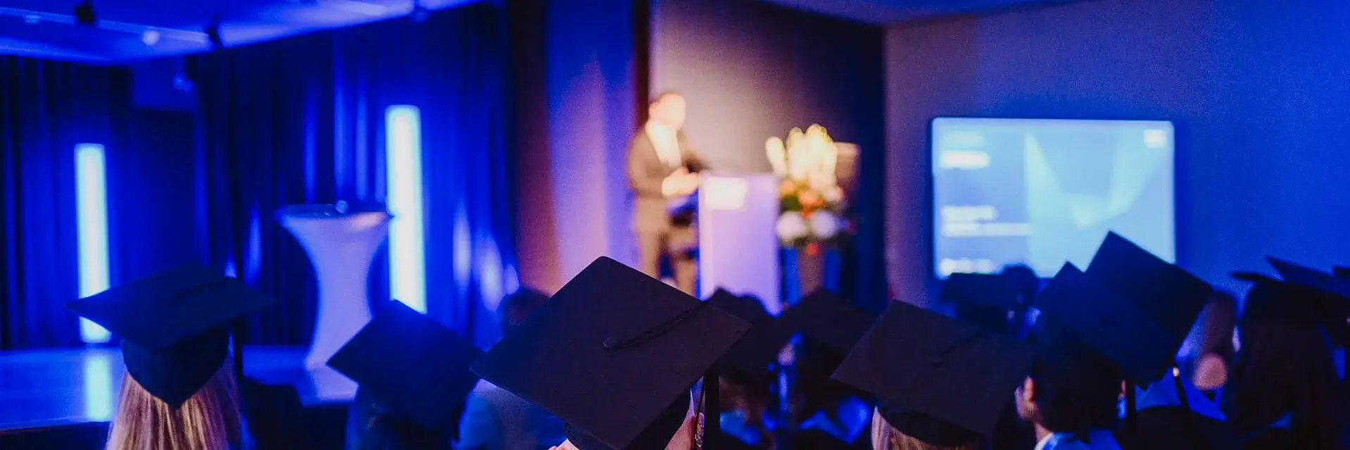 Alumni with graduation hats at Campus event