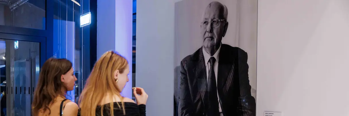 two women looking at a photography of Mikhail Gorbatshov
